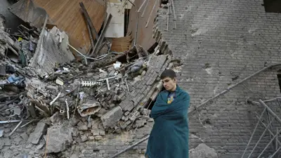 شخص يقف بجوار شقته دمرت بقصف روسي