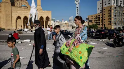 عائلة نازحة من سوريا تسعى إلى الانتقال إلى مكان آمن هربًا من الغارات الإسرائيلية على جنوب بيروت
