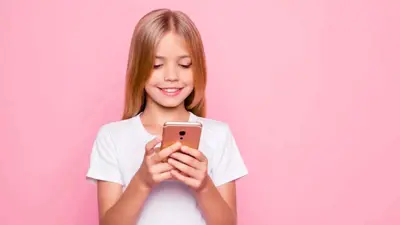 طفلة تحمل هاتفا ذكيا