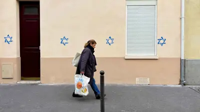 امرأة تمر أمام مبنى يحمل نجمة داود في باريس 