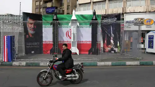 سائق يمر أمام نماذج وهمية لصواريخ في طهران