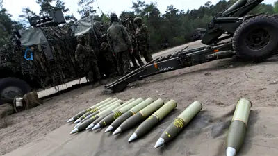 جنود أوروبيون يقفون أمام مجموعة من الذخائر