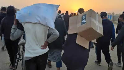 أشخاص يحملون المساعدات في غزة
