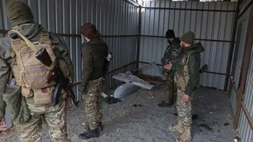 جنود سوريون خلال تفقدهم في وقت سابق مسيرة تابعة لقوات سوريا الديمقراطية