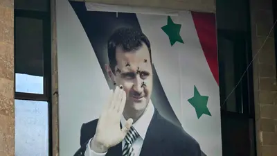 صورة لملصق مثقوب بالرصاص لبشار الأسد في حلب، سوريا