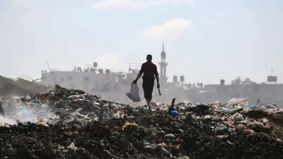 رجل فلسطيني يبحث عن أشياء لإنقاذها في مكب نفايات بمخيم البريج وسط قطاع غزة
