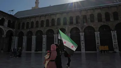 عائلة ترفع العلم السوري الجديد