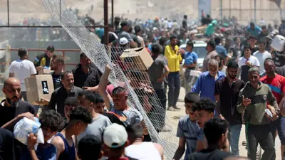 فلسطينيون يحملون مساعدات تلقوها من "غزة الإنسانية" 