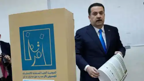 رئيس الوزراء العراقي محمد شياع السوداني يحمل ورقة اقتراع
