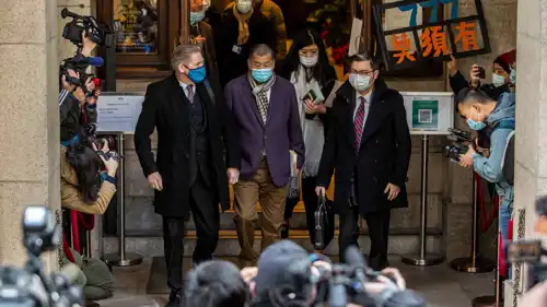 قطب الإعلام جيمي لاي (في الوسط) خلال خروجه من المحكمة