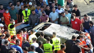 مسعفون يتفقدون سيارة استهدفتها غارة إسرائيلية في طرابلس