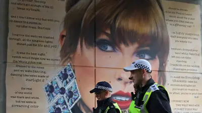 ضباط الشرطة يمرون أمام صورة لتايلور سويفت بملعب ويمبلي في لندن