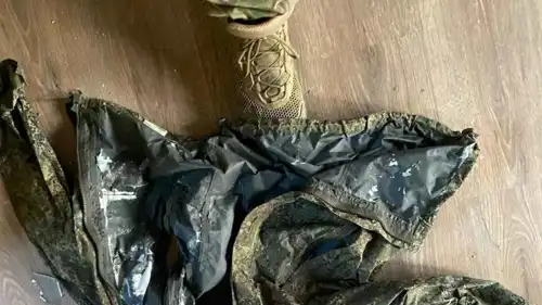 جندي أوكراني يقف فوق سترة تحمل شعارًا تمويهيًا