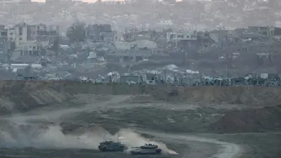 دبابات إسرائيلية ومن خلفها دمار قطاع غزة