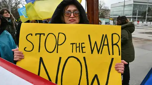 متظاهرة تحمل لافتة خلال محادثات جنيف