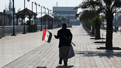 شخص يحمل العلم العراقي في العاصمة بغداد