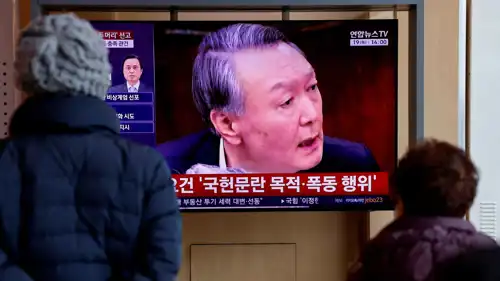 كوريون جنوبيون يتابعون تقريرا عن محاكمة الرئيس السابق