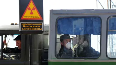 عمال بجانب لافتة تحذير من الإشعاع