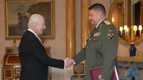  زالوزني يصافح ملك بريطانيا