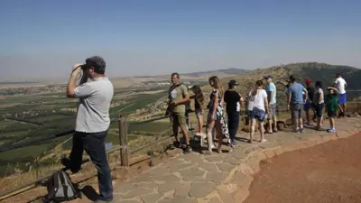 سياح إسرائيليون ينظرون إلى سوريا من هضبة الجولان