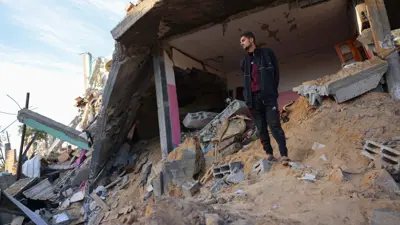 فلسطيني يقف على ركام منزله في غزة