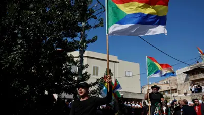 أشخاص يرفعون أعلام الموحدين الدروز