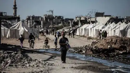 فلسطيني يسير داخل مخيم نازحين في غزة بعد وقف الحرب