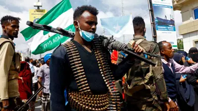 ضابط شرطة صومالي يقف حارسًا أثناء مسيرة ضد اتفاقية ميناء إثيوبيا