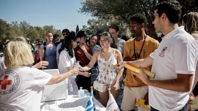 متطوعو الصليب الأحمر يوزعون المياه قرب الأكروبوليس وسط موجة حارة