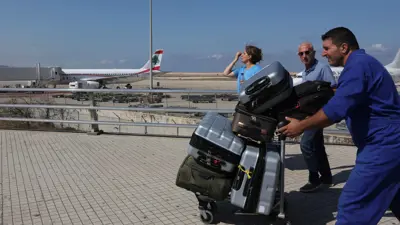 عامل يدفع عربة في مطار رفيق الحريري الدولي في بيروت