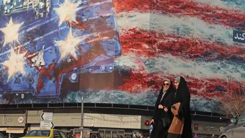 سيدتان إيرانيتان أمام جدارية في طهران