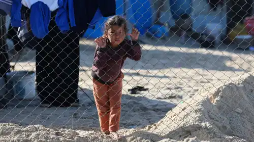 طفل تنظر من داخل أحد مخيمات النزوح في غزة