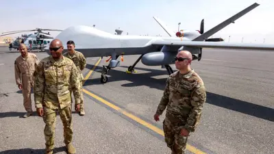طيارون من القوات الجوية الأميركية يقفون بالقرب من طائرة بدون طيار من طراز MQ-9 Reaper 