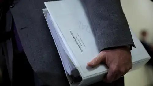 النائب الجمهوري جيمس كومر يحمل مجلدًا من وثائق إبستين