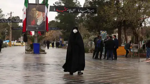 سيدة إيرانية تسير قرب علي خامنئي وسط طهران