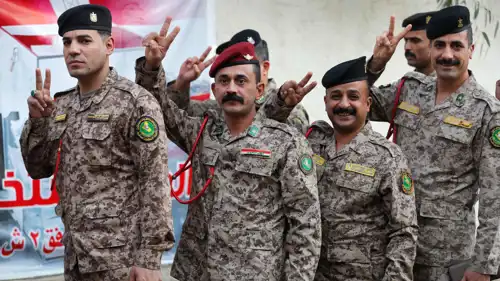 جنود عراقيون يلوحون بعلامة النصر قبل الإدلاء بأصواتهم