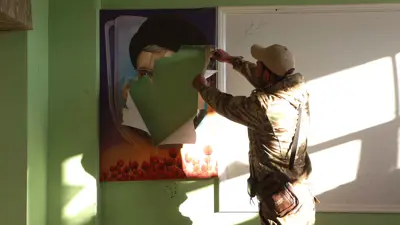 مسلح سوري أثناء تمزيق صورة حسن نصر الله في حمص