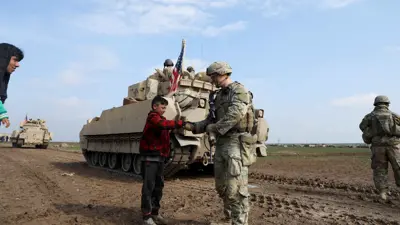 جندي أمريكي يصافح طفلا في القامشلي بسوريا