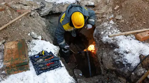 موظف يعمل لإعادة الكهرباء في كييف