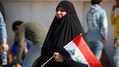 سيدة تحمل بيدها العلم العراقي