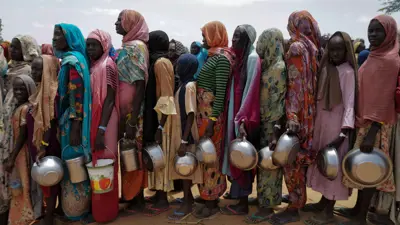 نساء سودانيات يصطففن لتلقي حصص الأرز من المتطوعين في أورانج على مشارف أدري