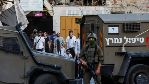 يقف أحد أفراد القوات الإسرائيلية حارسًا خلال جولة أسبوعية للمستوطنين في الخليل، في الضفة الغربية المحتلة