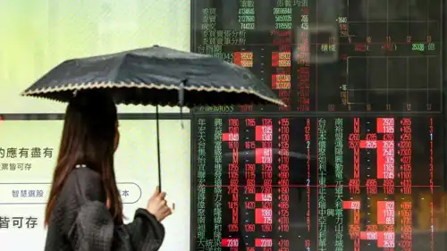 امرأة تنظر إلى مؤشر البورصة في هونغ كونغ