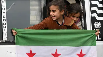 طفلة ترفع العلم السوري الجديد