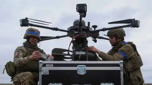 جنود أوكرانيون يعلقون قنابل جوية صغيرة على طائرة بدون طيار