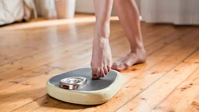 امرأة تقيس وزنها (تعبيرية)