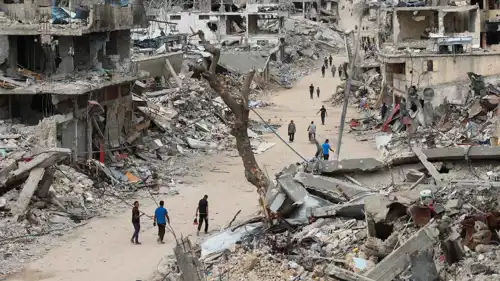 أشخاص يسيرون بين الدمار في غزة