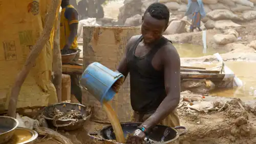 عمال مناجم يعالجون الغبار الناعم والتربة أثناء بحثهم عن الذهب في مستوطنة لعمال المناجم في أنكا، زامفارا، نيجيريا.