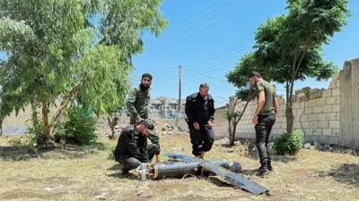 عناصر أمن سوريون يتفقدون مسيرة إيرانية 