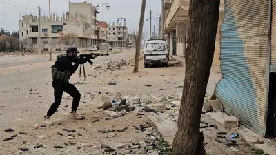 أحد أفراد قوات الأمن التابعة للسلطات السورية الجديدة يطلق النار من سلاحه في الصنمين، بمحافظة درعا الجنوبية